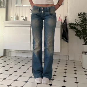 Lågmidjade jeans - Blåa lågmidjade jeans i storleken W26 L34 midjemåttet rakt över är 37 cm 