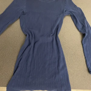 Mörkblå ribbad tröja - Snygg mörkblå ribbad tröja i bomull. Den har en enkel design med långa ärmar och en rund halsringning. Perfekt för en clean look!