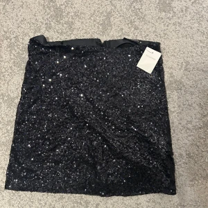 Svart paljettkjol - Snygg svart paljettkjol. Perfekt att ha när man går ut. Aldrig använd. 130kr