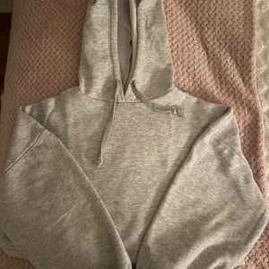 Grå croppad hoodie från Gina Tricot - Mysig grå croppad hoodie från Gina Tricot i storlek XXS (passar XS). Den har en justerbar huva med dragsko och en bekväm passform. Pris kan diskuteras!