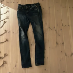 Blå jeans från Replay - Snygga blå jeans från Replay med en tight passform. De har en klassisk femficksdesign och är tillverkade i ett stretchigt material för extra komfort. Perfekta för en stilren look. Säljer dem för att dem är för små. Den passar dig som är runt 170-175