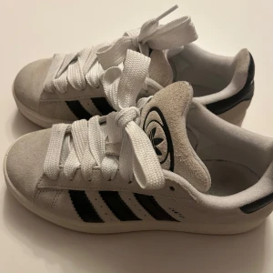 Adidas Campus  - Säljer nu mina Adidas Campus sneakers i beige/ grå mocka med  svarta detaljer. Säljer de eftersom jag är ute efter annan färg. De är i bra skick, det är inga defekter. Använd några gånger. Funderingar? Hör gärna av er isåfall!💓