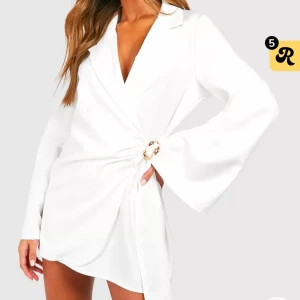 Vit omlottklänning med knyt - Elegant vit omlottklänning med knyt och dekorativ ringdetalj i midjan. Klänningen har långa ärmar och en stilren design som passar perfekt för festliga tillfällen. Den hann ej komma till tillställning så har inte äns använt den. Kan mötas upp i Stockholm 