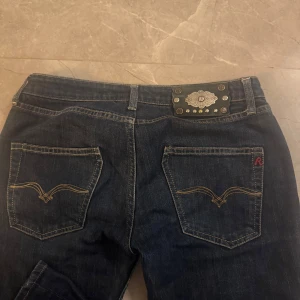 Mörkblå jeans från Replay - Jag säljer ett par lågmidjade, straight leg jeans från Replay som har jättefina fickor och väldigt populära. Har endast kommit till användning ett få tal gånger. Storleken på jeansen är 27/32.
