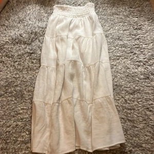 Vit långkjol från H&M - Säljer en vit långkjol från H&M. Kjolen har ett luftigt tyg. Perfekt för varma dagar.