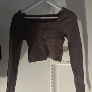 Brun stickad tröja - Säljer en brun stickad tröja med lång ärm och en croppad design. Perfekt för kyligare dagar och ger en stilren look. Passar bra till både jeans och kjol.