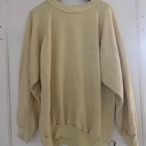 Beige sweatshirt från Trikå - Säljer en beige sweatshirt från Trikå. Tröjan har en klassisk design med långa ärmar och ribbade muddar vid ärmslut och nederkant. Perfekt för en avslappnad stil.