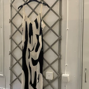 Klänning shein - En svartvit klänning med ett abstrakt mönster. Klänningen är i en mjukt fallande modell med tunna axelband. Den är helt ny och aldrig använd från Shein!