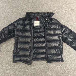 Mörk blå dunjacka från Moncler - Säljer en snygg mörk blå dunjacka från Moncler. Jackan har en glansig finish och är utrustad med dragkedja. Perfekt för kyligare dagar med sin stilrena design och varma material. Skick 9,5/10 som ny knappt använd.