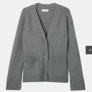 Grå kofta från Wera - Säljer en grå kofta från Wera. Den har en v-ringad design med knappar framtill och två praktiska fickor. Koftan är långärmad och har ribbade muddar vid ärmslut och nederkant. 