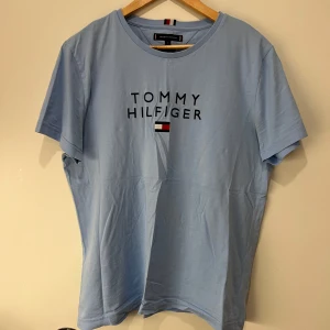 Ljusblå t-shirt från Tommy Hilfiger - Snygg ljusblå t-shirt från Tommy Hilfiger i ekologisk bomull. Använt ett par gånger men är i nyskick och inga tecken på slitage! Sälja för ett mycket bra pris 👍