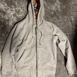 Burberry Clarendon Hoodie - Hej! Säljer nu en Burberry Clarendon zip hoodie i storleken M. Riktigt fet hoodie då den har Burberrys ikoniska mönster! Hoodie är använd men i gott skick! Självklart äkta! Köpt av en vän denna gång och från början köpt i Butik i Köpenhamn för många år sedan då denna hoodie var i kollektionen! Nypris ca 9000kr mitt pris 1500kr. Pris i princip hugget i sten. Tveka ej att höra av dig!