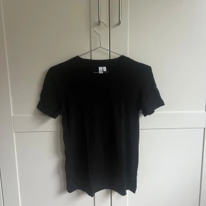 Svart t-shirt från &otherstories - Säljer en klassisk svart t-shirt från &otherstories. Den har en normal passform och är ett perfekt basplagg för alla tillfällen. Säljer för 120kr + frakt. Endast använd en gång.