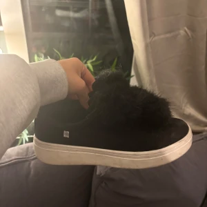 Svarta sneakers med pälsdetalj - Snygga svarta sneakers med en fluffig pälsdetalj på ovansidan. Skorna har en vit sula som ger en fin kontrast till det svarta. Perfekta för en trendig look. Köpta från Massimo dutti💕