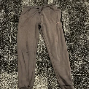 Grå mjukisbyxor från McKenzie - Säljer ett par grå mjukisbyxor från McKenzie. De har en bekväm passform med snörning i midjan och ribbade muddar vid bensluten. Perfekta för en avslappnad stil.