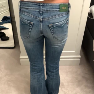 Intressekoll på jeans  - INTRESSEKOLL Snygga blå jeans från Replay med bootcut-stil. De har en klassisk femficksdesign och en knappgylf. Perfekta för en avslappnad look. MIDJEMÅTT: 36cm INNERBENSLÄNGD: 74cm