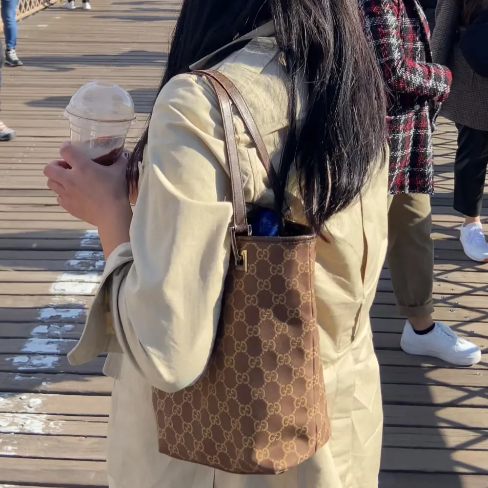 Snygg brun axelväska från Gucci med det klassiska GG-mönstret. . Laukut & Käsilaukut.