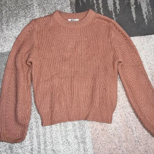 Rosa stickad tröja från Zara - Mysig rosa stickad tröja från Zara med rund hals och långa ärmar. Perfekt för kyliga dagar och ger en avslappnad look. Ribbstickade muddar vid ärmslut och nederkant för extra komfort.