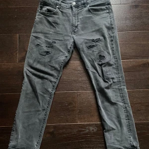 Jeans med slitningar - Snygga grå/svarta jeans från wranglar med snygga slitningar. Dem är använda men fortfarande i väldigt bra skick. Hör av er vid några funderingar 😊
