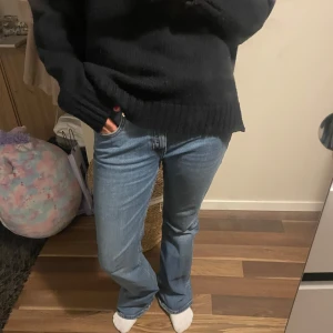 Blå bootcut jeans - Säljer ett par klassiska blå bootcut jeans. De har en snygg passform som sitter bra över höfterna och går ut vid benen. Perfekta för en avslappnad stil.