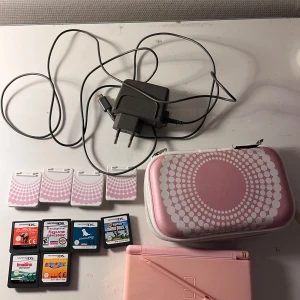 Rosa Nintendo DS Lite med tillbehör - Nitendo ds lite i bra skick och har inga repor, batteriet är utbytt och nytt.  Nitendo med fodral och spel skydd  kostar 900 kr. Spelen kostar 50kr/st och laddaren 99kr. Man kan också köpa allt för 1 250 kr 