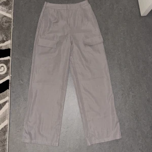 Grå cargopants med tubtopp - Snygga grå cargopants med raka ben och praktiska fickor på sidorna. Matchande tubtopp i samma grå nyans. Perfekt set för en stilren look.