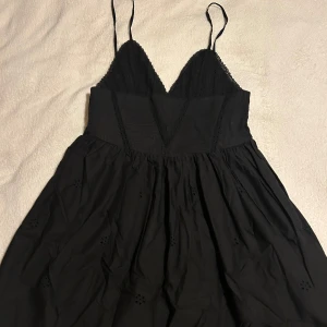 Svart klänning från Zara - Helt ny med prislapp säljer pga för liten i storleken. Snygg svart klänning från Zara med smala axelband och spetsdetaljer. Den har en v-ringad design och ett fint fall. Perfekt för en stilren look. Pris kan alltid diskuteras 😊