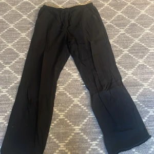 Svarta byxor med snörning - Snygga svarta byxor med loose passform och snörning i midjan. Perfekta för en avslappnad stil. De har en rak och vid stil som ger en bekväm känsla. Gina Young linnebyxor 