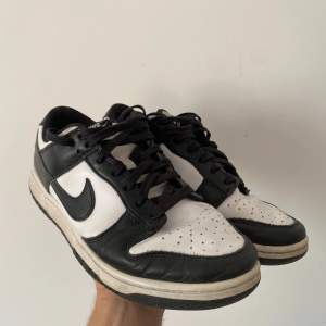 Nike Dunk Low Panda i storlek EU 42.5/US 9. Skick: 6/10. Skorna är använda men har mycket liv kvar, en del creasing och en liten spricka framtill på ena skon. Låda saknas. Bara att skriva för fler bilder!