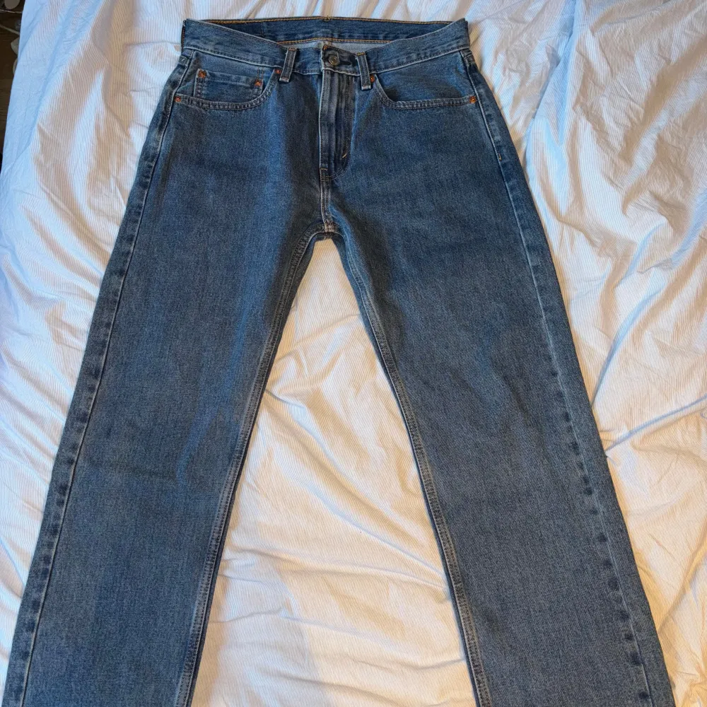 Säljer ett par klassiska Levi's 505 jeans i blå denim. De har en straight passform och är i bra skick. Perfekta för en avslappnad stil och funkar året runt. Jeansens kvalitet är på topp med den ikoniska Levi's-lappen baktill.. Jeans & Byxor.