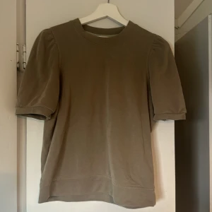 Beige kortärmad tröja - Säljer en stilren och enkel grön tröja med korta ärmar. 