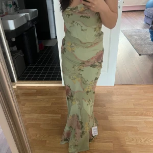 Blommig grön Balklänning - Helt ny, oanvänd balklänning som kan funka till andra tillfällen såsom t.ex bröllop. Säljer då den inte kommer till användning. Lappen finns kvar. Vid frågor kan man skriva💕