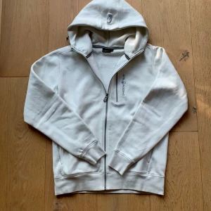 Vit hoodie från Sail Racing - Helt ny och oanvänd Sail Racing Bowman zip up hoodie. Köptes för 1500kr men säljs eftersom den ej kommer till användning.