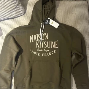 Maison kitsune hoodie - Säljer denna populära hoodie i färgen olivgrön. Tröjan är helt ny med tags och är endast testad. Hör av er om funderingar och liknande. Priset är ej hugget i sten.