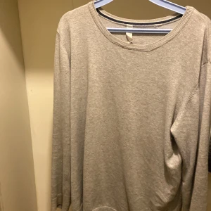 Grå långärmad tröja - Säljer en enkel och stilren grå långärmad tröja. Perfekt för en avslappnad look. Tröjan har en rund halsringning och är gjord i ett mjukt material.