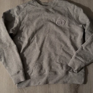 Grå CD sweatshirt  - Grå CD sweatshirt, nästan aldrig använd. Tvättad en gång, lite för stor för mig.