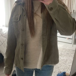 Grön jacka från Part Two - Säljer en snygg grön jacka från Part Two. Jackan har en klassisk design med knappar framtill och två bröstfickor med. Passar bra till jeans och en enkel tröja.