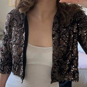 Säljer en snygg glittrig bolero från Zara Knit. Bolero är croppad och har korta ärmar. Storlek L men passar mer S-M