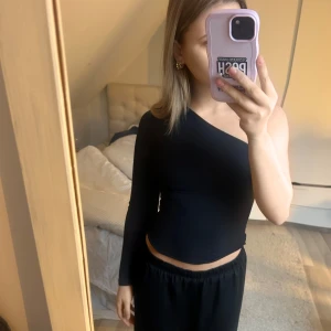 Svart oneshoulder topp - Snygg svart oneshoulder topp med lång ärm.  Passar bra till både kjol och byxor.🫶💕
