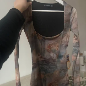 Mönstrad klänning från Prettylittlething - Unik klänning med konstnärligt mönster från prettylittlething. Den har en tight passform och långa ärmar. Perfekt för dig som vill sticka ut med en konstnärlig touch. Aldrig använd 😊