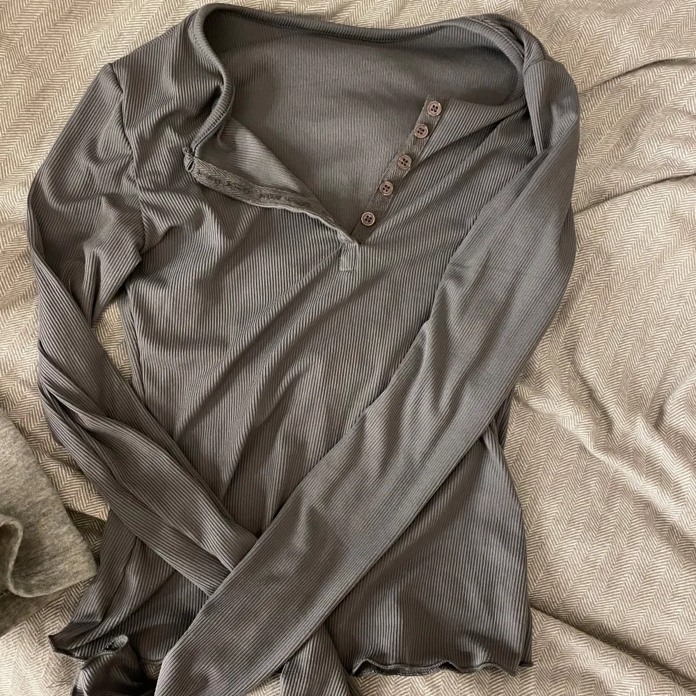 Snygg grå långärmad topp med knappar framtill. Perfekt för en stilren look. Passar bra till både jeans och kjol. Aldrig använd. Passar mig som använder S.🩵🤍. Neuletakit & Villapaidat.