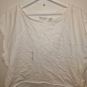 Vit t-shirt från Reebok - Säljer en vit t-shirt från Reebok. T-shirten är snyggare på då den har blivit något skrynklig i garderoben. 