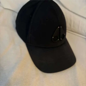 Svart keps med logotyp - Snygg svart keps med en diskret logotyp framtill. Perfekt för en stilren look. Kepsen har en klassisk design med böjd skärm och justerbar passform.