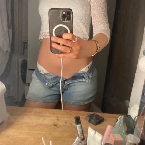 Blå jeansshorts från Levi's - Snygga blå jeansshorts från Levi's med klassisk femficksdesign och knappgylf. Perfekta för en avslappnad sommarlook. De är lågmidjade och har en normal passform som ger en bekväm känsla.