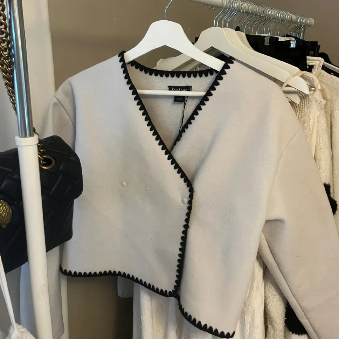 Vit jacka med svarta sömmar 