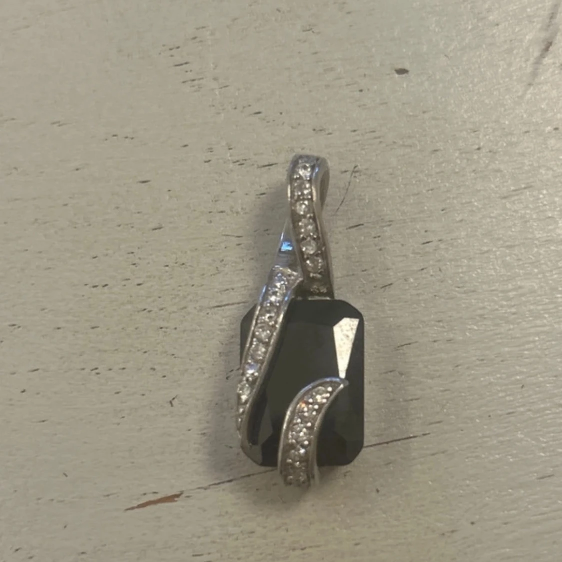 Silverfärgat hänge med svart sten