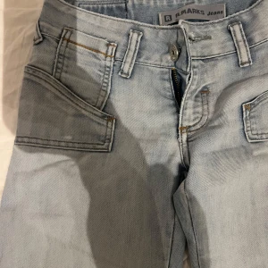 Ljusblå jeans från R.Marks - Snygga ljusblå jeans från R.Marks med klassisk femficksdesign och knappgylf. Perfekta för en avslappnad stil.