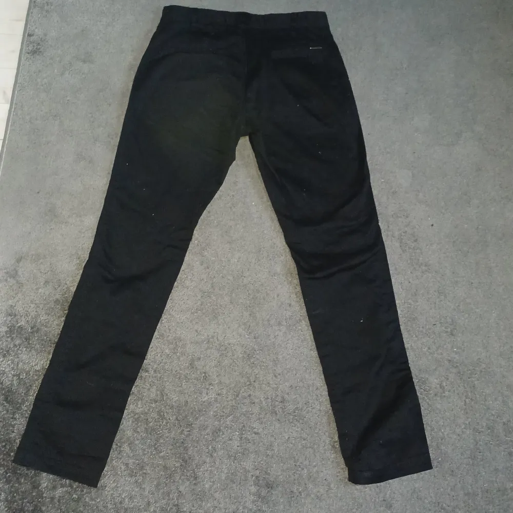 Snygga svarta byxor från Bruun & Stengade i slim fit. Perfekta för en stilren look med en klassisk design. Byxorna har en midwaist och är tillverkade i ett bekvämt material.. Farkut & Housut.
