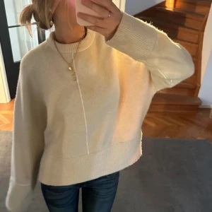 Beige stickad tröja - Säljer en mysig beige stickad tröja med långa ärmar och ribbade muddar. Perfekt för kyligare dagar och enkel att matcha med jeans eller kjol. Tröjan har en avslappnad passform och är superbekväm att bära. Hör av dig vid intresse! 😊