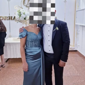 Blå långklänning med pärlor - Elegant blå långklänning med pärlor och glittrig detaljering på överdelen. Klänningen har en axelbandslös design med en vacker drapering i midjan. Perfekt för en speciell kväll!